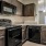 Spacious and well lit kitchen with wood floors and stainless steel appliances. 